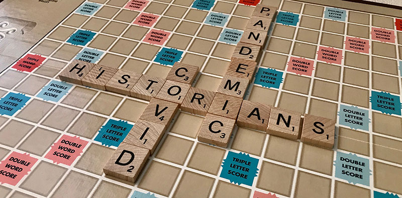 Scrabble board spelling out the words "Historians," "COVID," and "Pandemic"